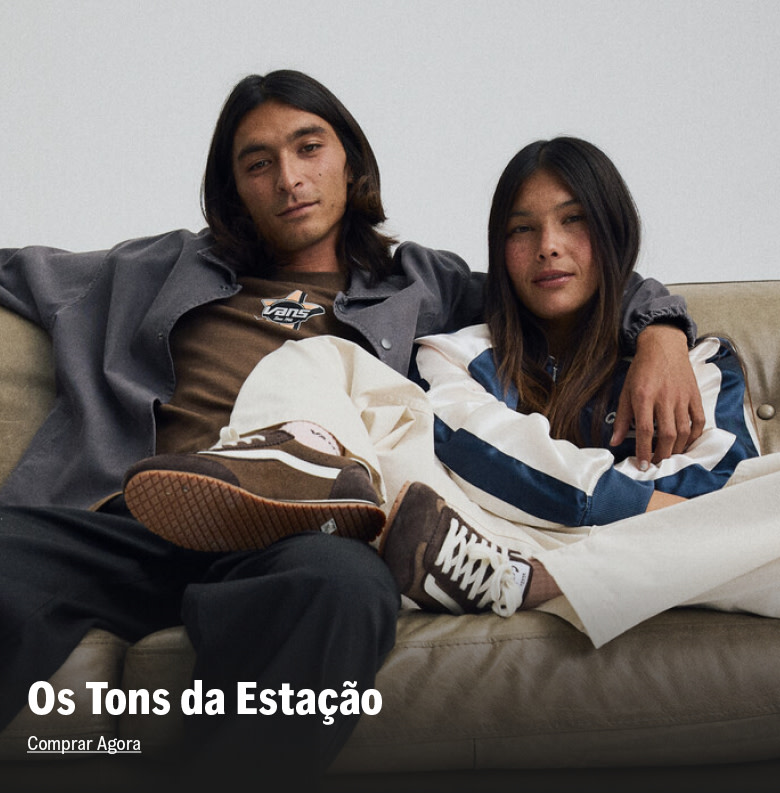 Casal sentado em sofá usando roupas em tons invernais